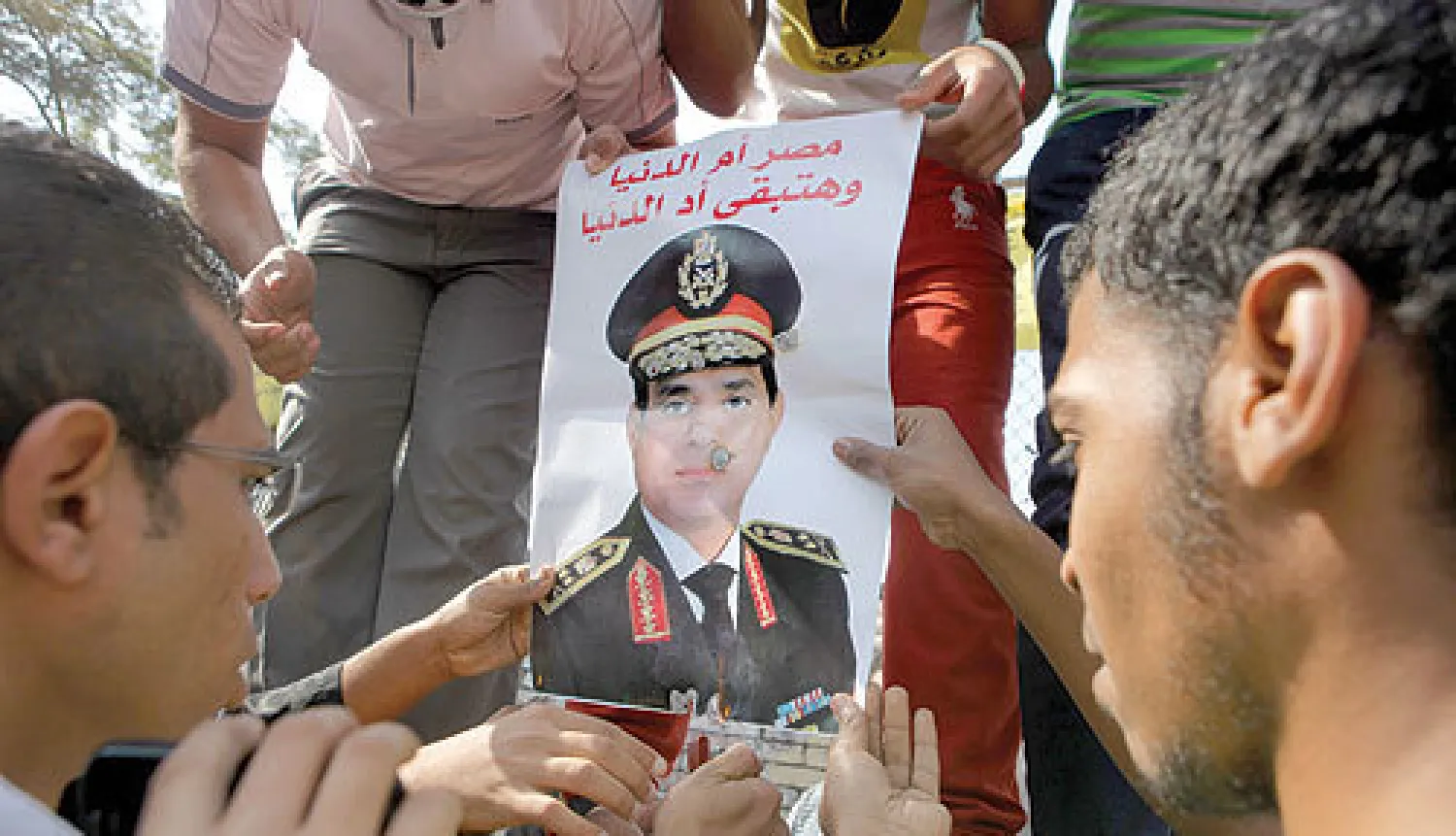 مؤيدو الجيش يحملون صورة الفريق أول عبد الفتاح السيسي وزير الدفاع المصري في أحد ميادين القاهرة أمس (أ.ب)