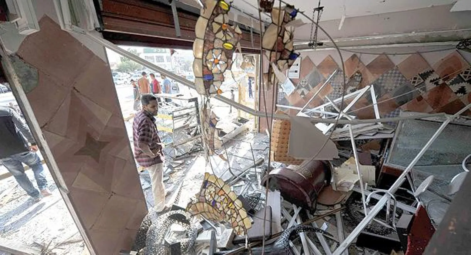 ليبي ينظر إلى الدمار الذي لحق بكافيتريا في مدينة بنغازي بسبب تفجير عبوة ناسفة أمس (رويترز)