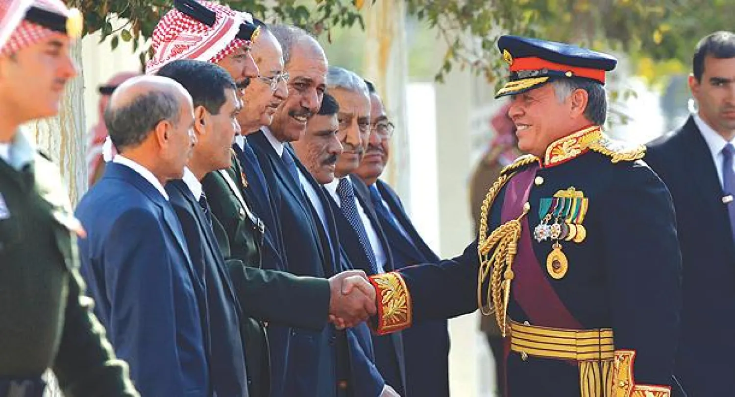 الملك عبد الله الثاني يصافح مسؤولين قبيل افتتاح الدورة العادية الأولى لمجلس الأمة، أمس (رويترز)