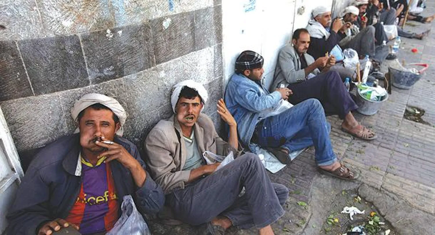 يمنيون يصطفون في انتظار فرص عمل في أحد شوارع صنعاء أمس (رويترز)