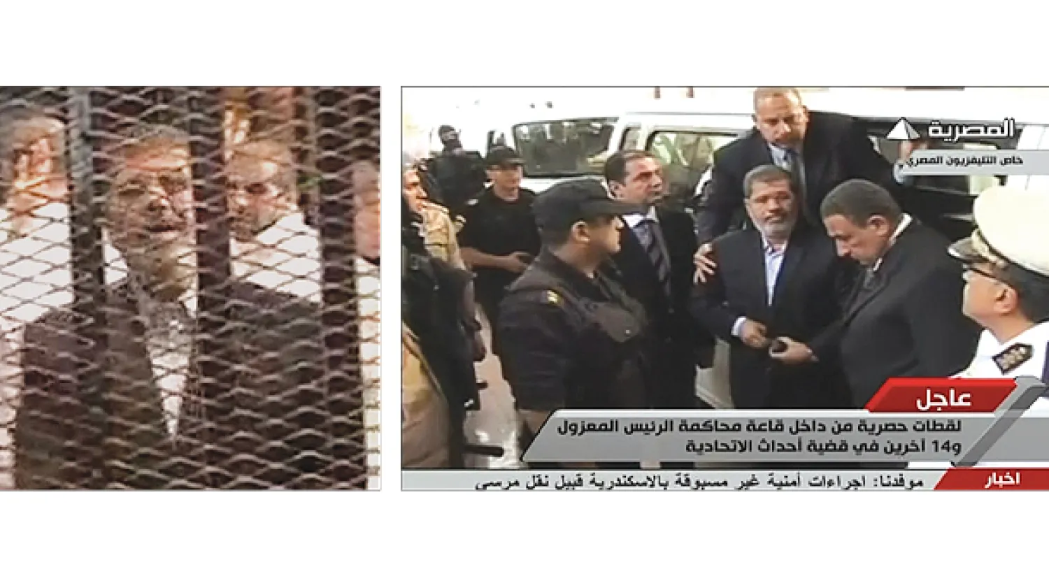 الرئيس المصري السابق محمد مرسي لحظة وصوله لمقر محاكمته في أكاديمية الشرطة أمس.. وفي قفص الاتهام مع عدد من قيادات الإخوان (رويترز)