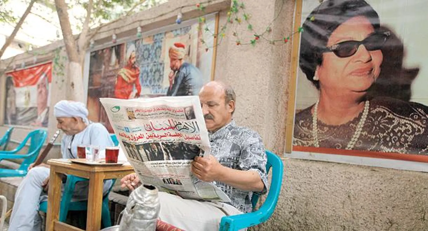 مصري يقرأ صحيفته المحلية على أحد مقاهي وسط القاهرة أمس (أ.ب)