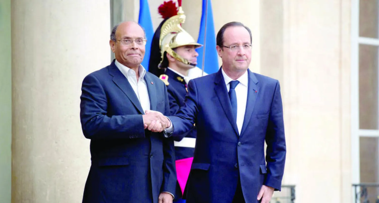 الرئيس الفرنسي فرنسوا هولاند لدى استقباله الرئيس التونسي المنصف المرزوقي أمام قصر الإليزيه بباريس أمس (أ.ف.ب)