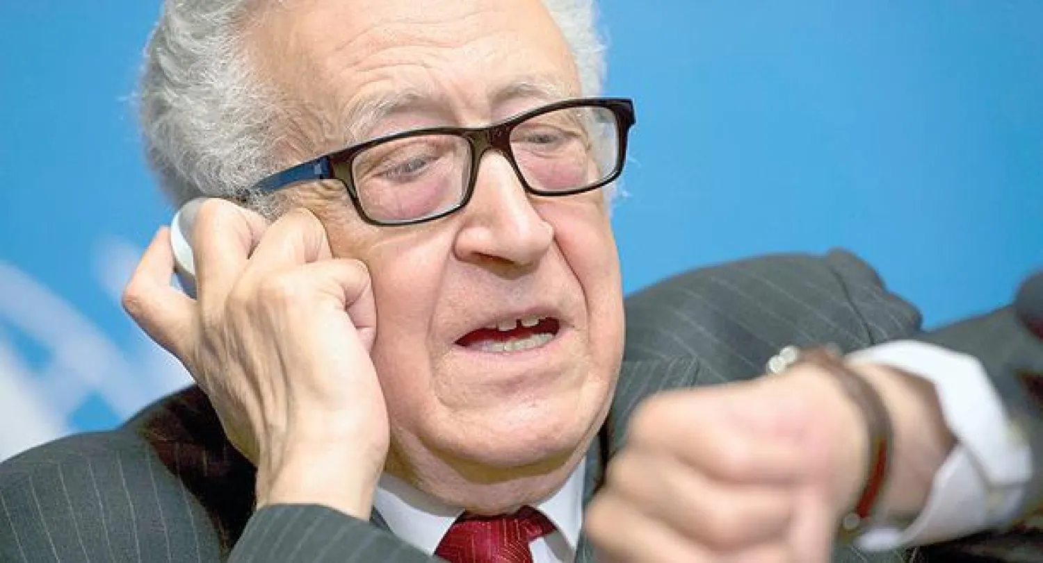 المبعوث الدولي والعربي الأخضر الإبراهيمي يعاين ساعته خلال مؤتمر صحافي في جنيف أمس (إ.ب.أ)