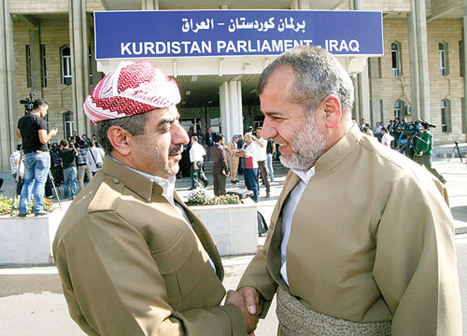 نائبان كرديان بعد اختتام الجلسة الافتتاحية للبرلمان الكردستاني المنتخب في أربيل أمس (أ.ف.ب)