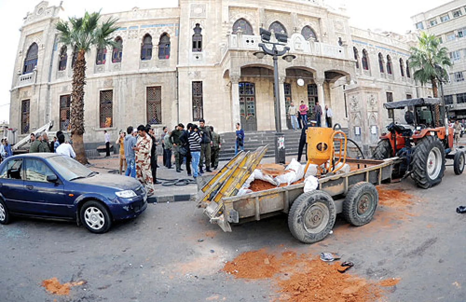 سوريون متجمعون أمام مبنى المؤسسة العامة للخط الحديدي في ساحة الحجاز بعد انفجار أودى بحياة ثمانية أشخاص (أ.ف.ب)