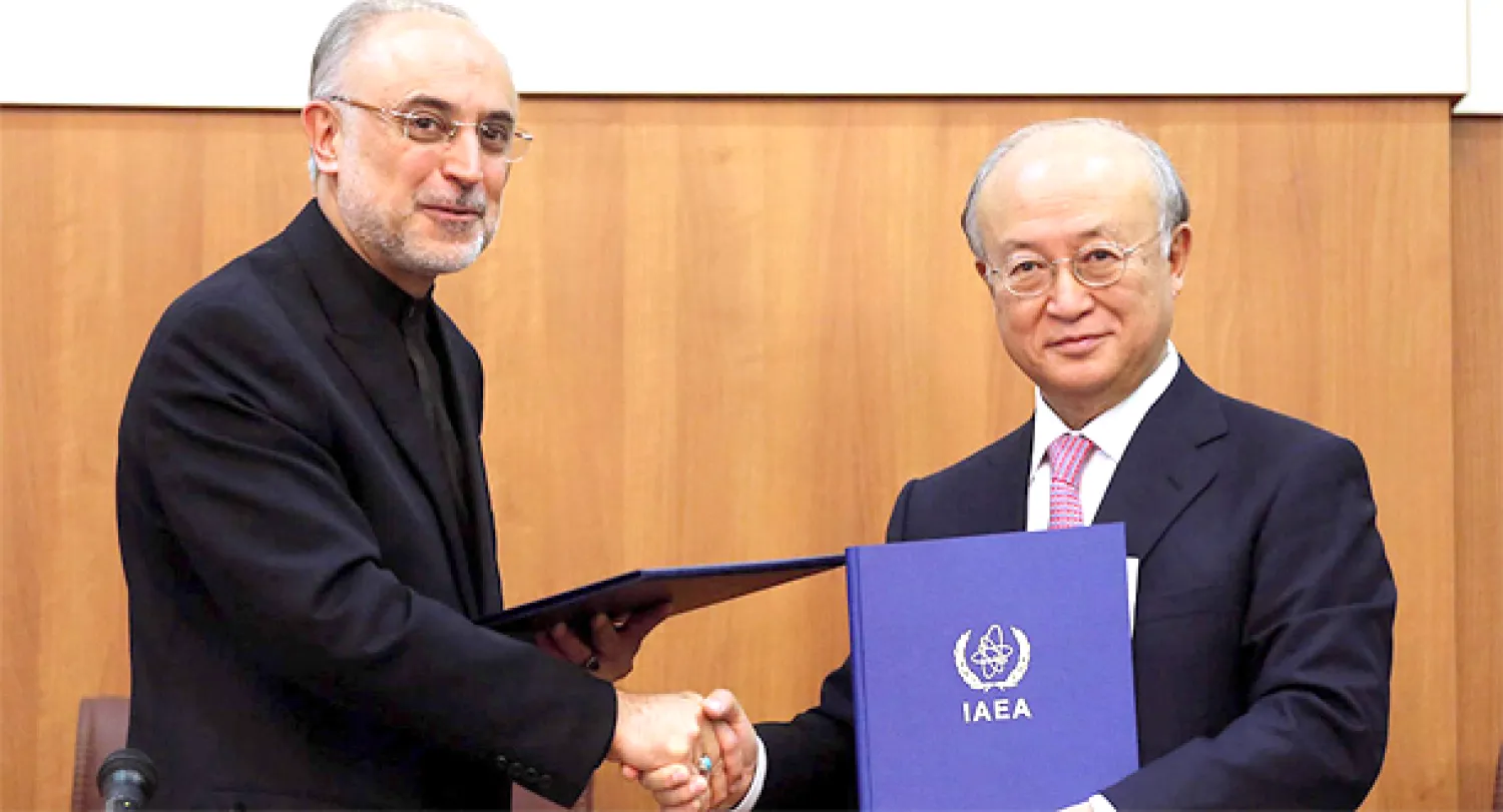 رئيس منظمة الطاقة الذرية الايرانية علي أكبر صالحي مصافحا المدير العام للوكالة الدولية للطاقة الذرية يوكيا أمانو بعد التوقيع على الاتفاق 