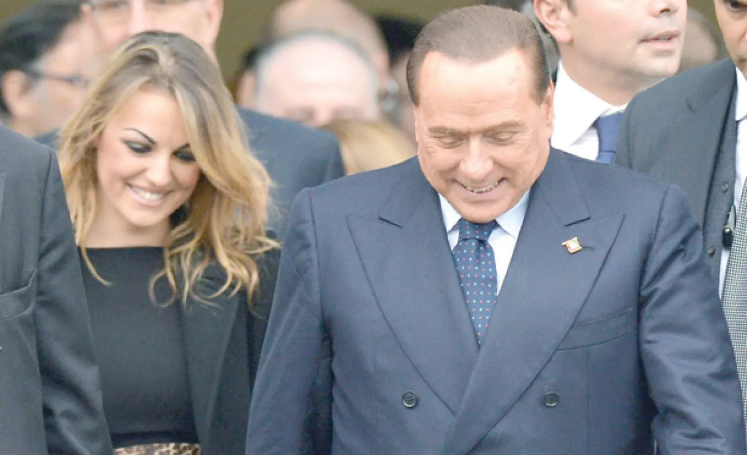 برلسكوني يغادر برفقة صديقته فرانسيسكا باسكال  اجتماع المجلس الوطني لحزبه في روما أمس (إ.ب.أ)