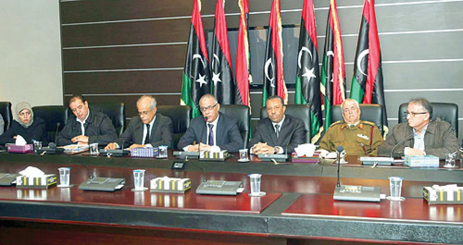 علي زيدان رئيس الحكومة الانتقالية مع عدد من المسؤولين خلال المؤتمر الصحافي الذي عقده في العاصمة طرابلس أمس (إ.ب.أ)