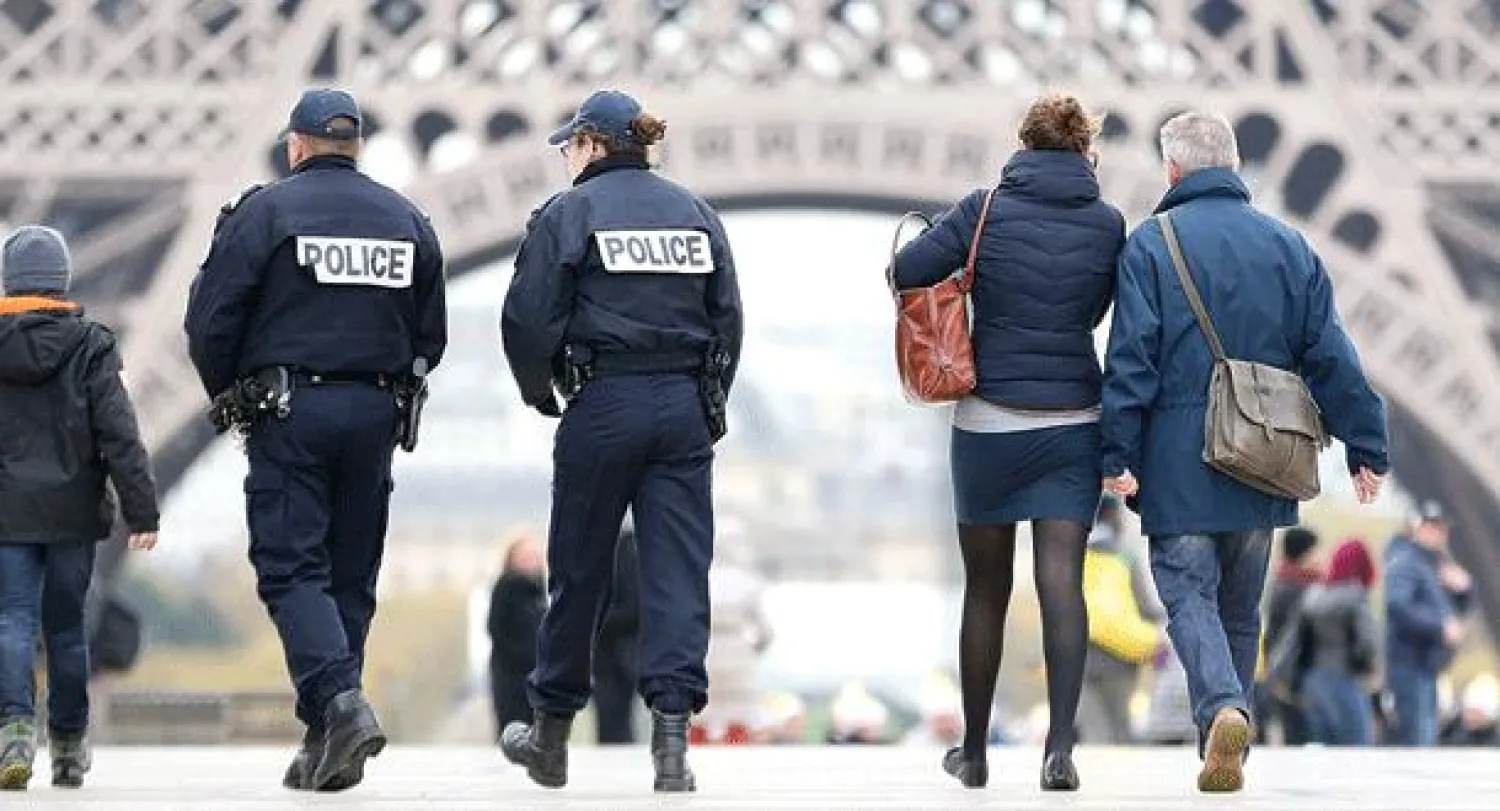 شرطيان يراقبان الوضع أمام برج إيفل بقلب باريس أمس (إ.ب.أ)