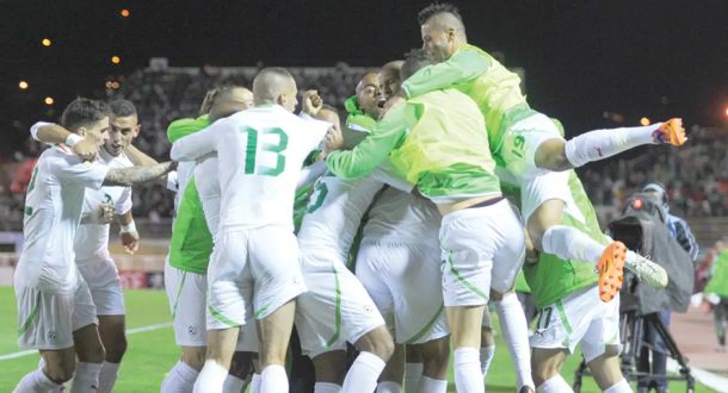 لاعبو منتخب الجزائر يحيطون ببوقرة للاحتفال بالهدف الذي قادهم لمونديال البرازيل (أ.ف.ب)