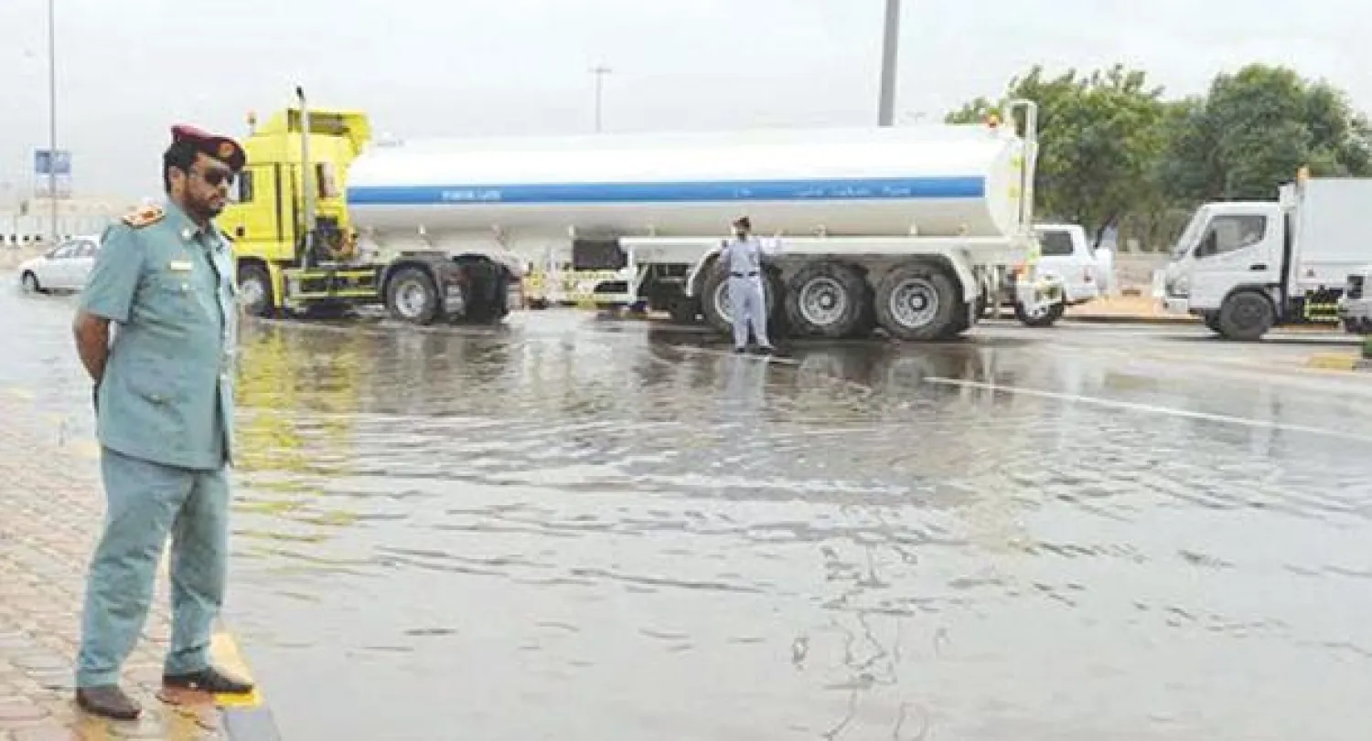 رجل أمن يتابع عملية تصريف مياه الأمطار في مدينة العين في الامارات