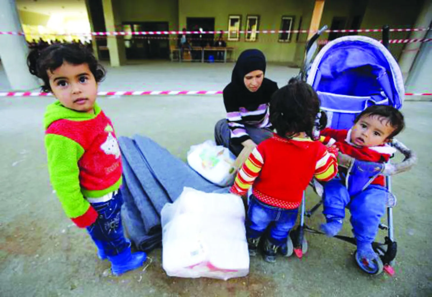 لاجئة سورية هربت خشية ضياع أرواح أطفالها وتحمل مساعدات الأمم المتحدة في لبنان نهاية الأسبوع الماضي (أ.ف.ب)