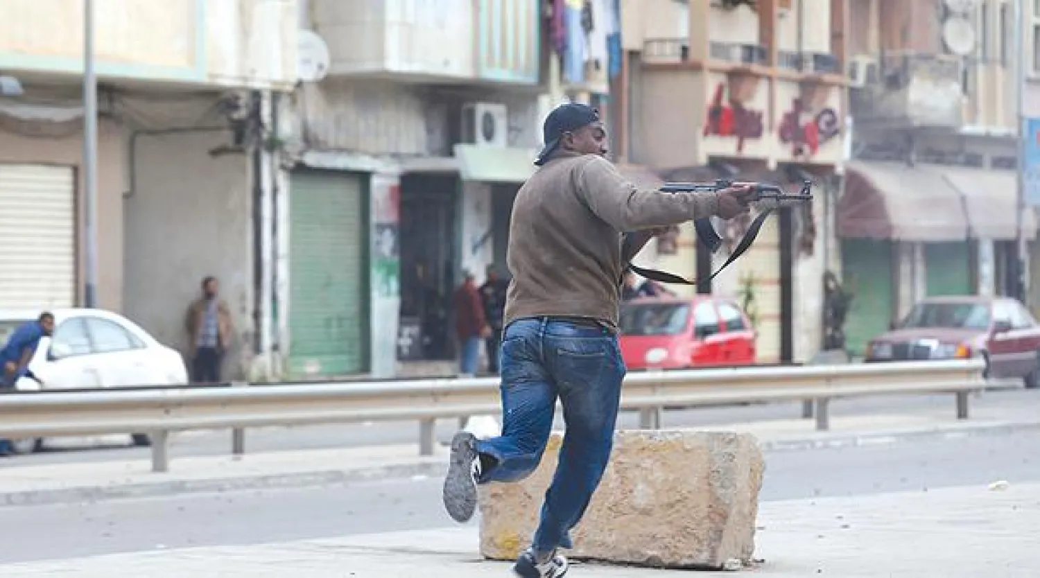 مواطن يطلق النار على عناصر من ميليشيات تنظيم أنصار الشريعة المتطرف مؤازرة للجيش الليبي في مدينة بنغازي أمس (رويترز)