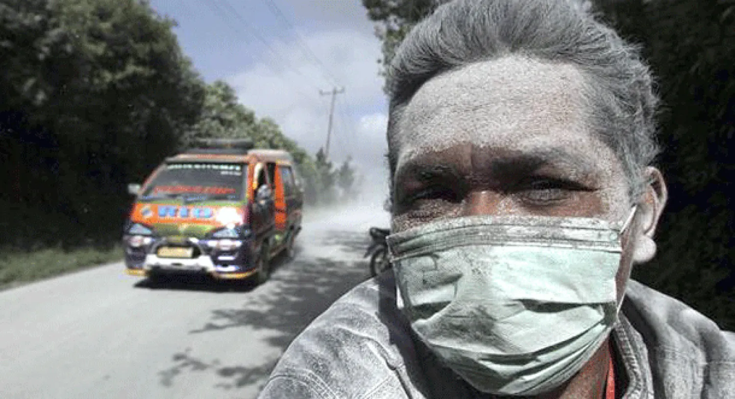 .       مواطن أندونيسي يضع كمامة على فمه وأنفه لكثرة انتشار الرماد في قرية كارو بعد ثوران بركان سينابورغ