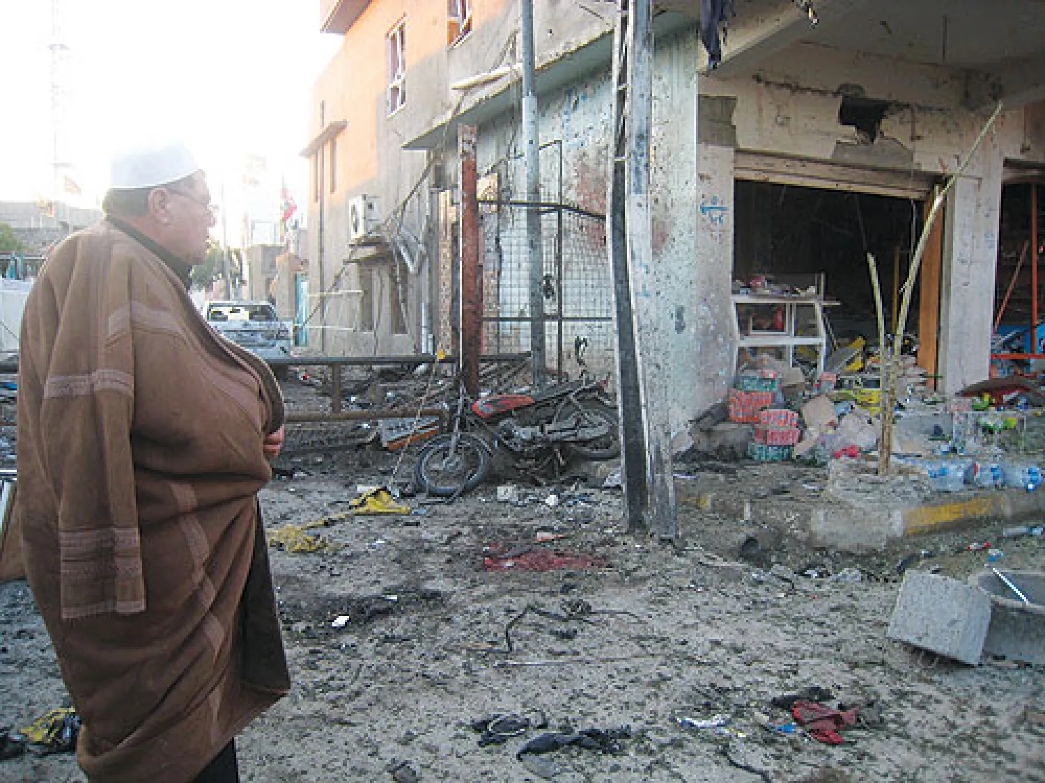 عراقي يعاين أمس آثار تفجير انتحاري شهدته بلدة طوز خورماتو أول من أمس (أ.ف.ب)