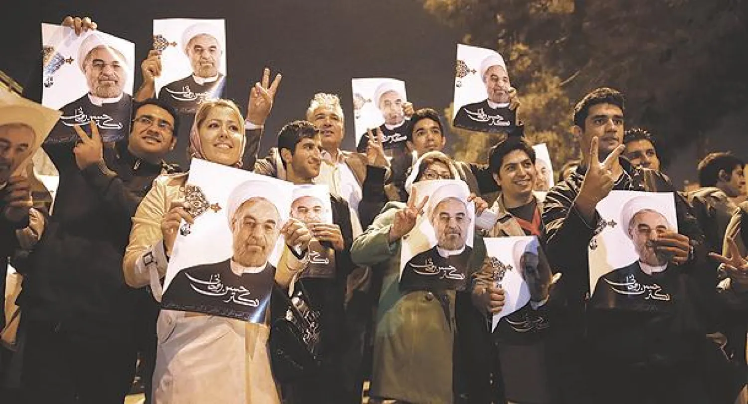 طلاب إيرانيون يرفعون صور الرئيس حسن روحاني لدى استقبالهم الفريق الإيراني المفاوض في مطار طهران أول من أمس (أ.ب)