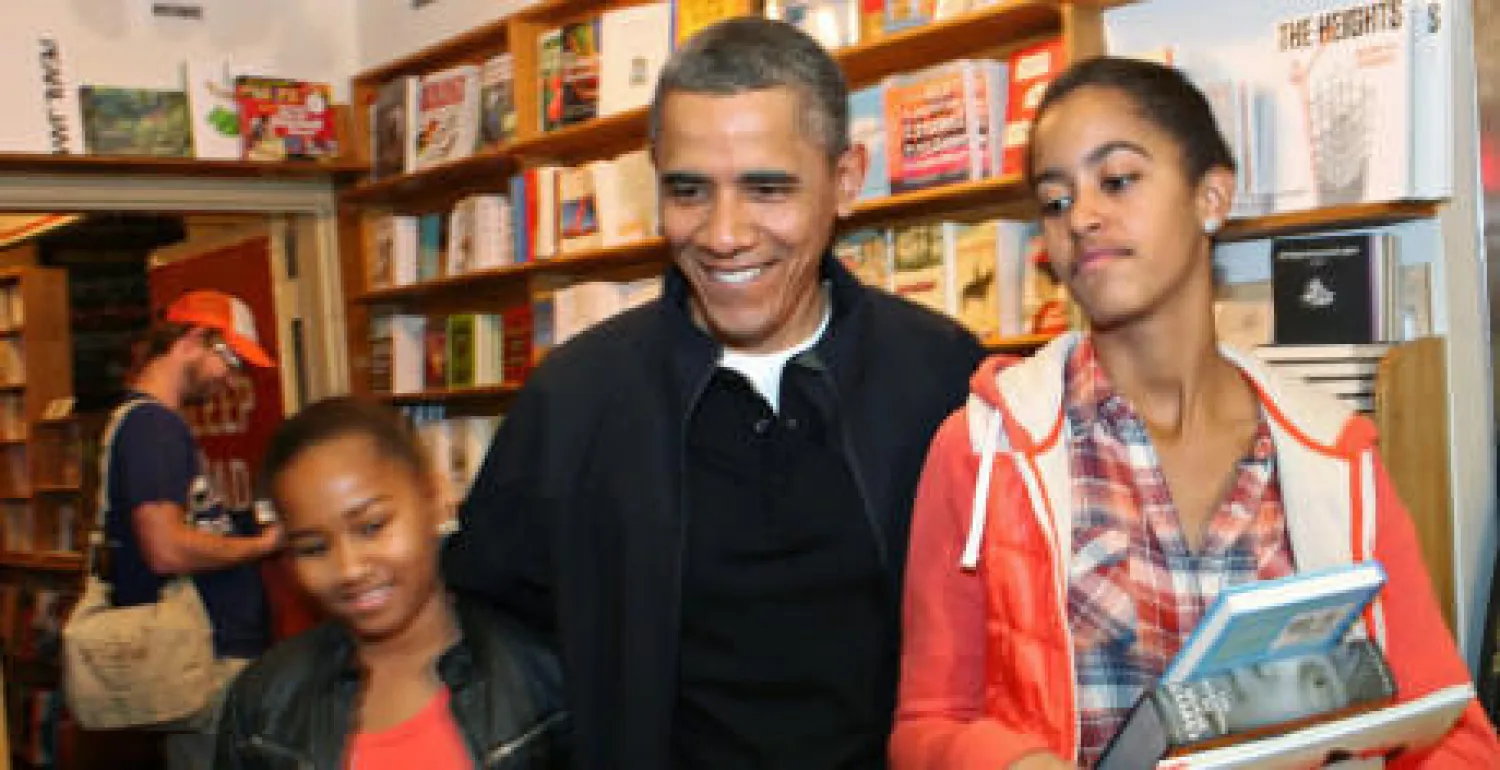 أوباما مع ابنتيه خلال شراء كتب بمتجر محلي صغير في العاصمة واشنطن (الهافنغتون بوست)