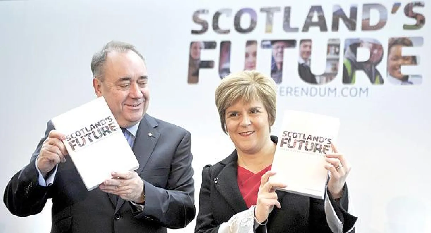 رئيس الوزراء الاسكوتلندي سالموند ونائبته ستيرجن يعرضان «الكتاب الأبيض}  الخاص بمشروع الاستقلال في غلاسكو أمس (أ.ف.ب)
