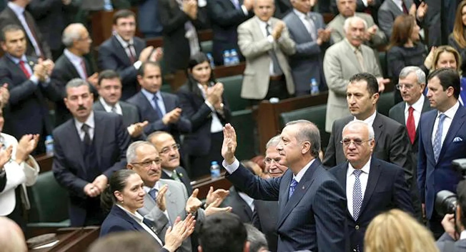رئيس الوزراء التركي رجب طيب أردوغان يحيي نواب من كتلة حزبه {العدالة والتنمية} أثناء اجتماع له في البرلمان بأنقرة أمس (أ.ف.ب)