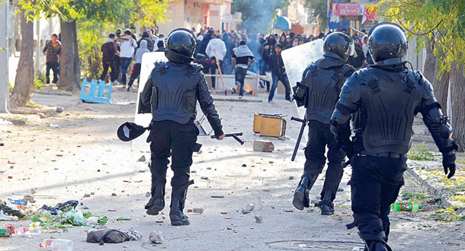 محتجون ضد حكومة «النهضة» يرشقون عناصر الأمن التونسيين بالحجارة أثناء مواجهات بمدينة سليانة أمس (أ.ف.ب)