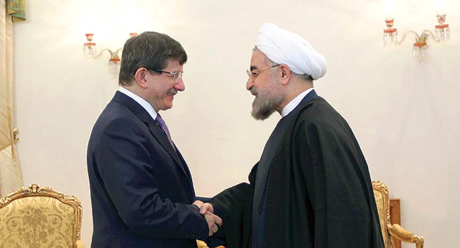 الرئيس الايراني حسن روحاني خلال استقباله وزير خارجية تركيا أحمد داود أوغلو في طهران أمس (أ.ب)