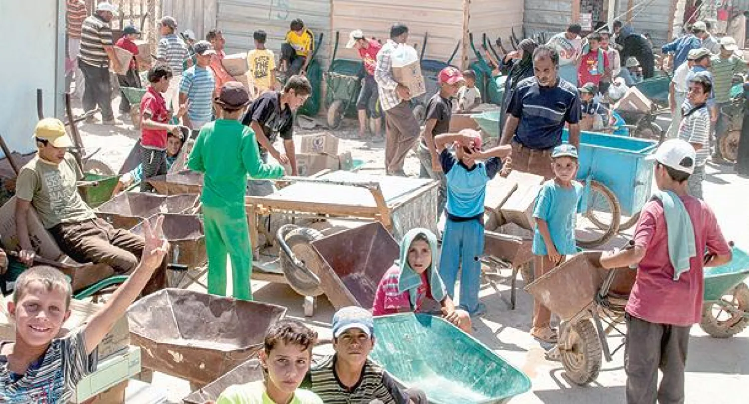 صورة نشرتها اليوم لجنة تحقيق الأمم المتحدة حول اللاجئين تظهر أطفالا يعملون في ورشة بناء في مخيم الزعتري بالأردن (أ.ب)