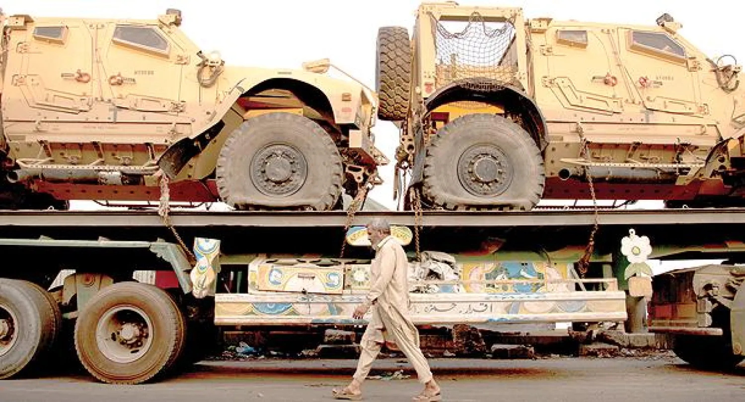 مواطن باكستاني يسير بمحاذاة ناقلة عربات عسكرية تابعة للناتو في كراتشي في طريقها إلى أفغانستان يوم الثلاثاء الماضي (أ.ب)