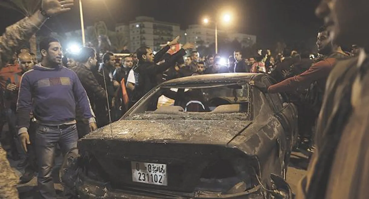 ليبيون يعاينون موقع تفجير استهدف مسيرة تأييد للجيش والشرطة وتنديد بمجموعة «أنصار الشريعة» في بنغازي يوم الجمعة الماضي (رويترز)