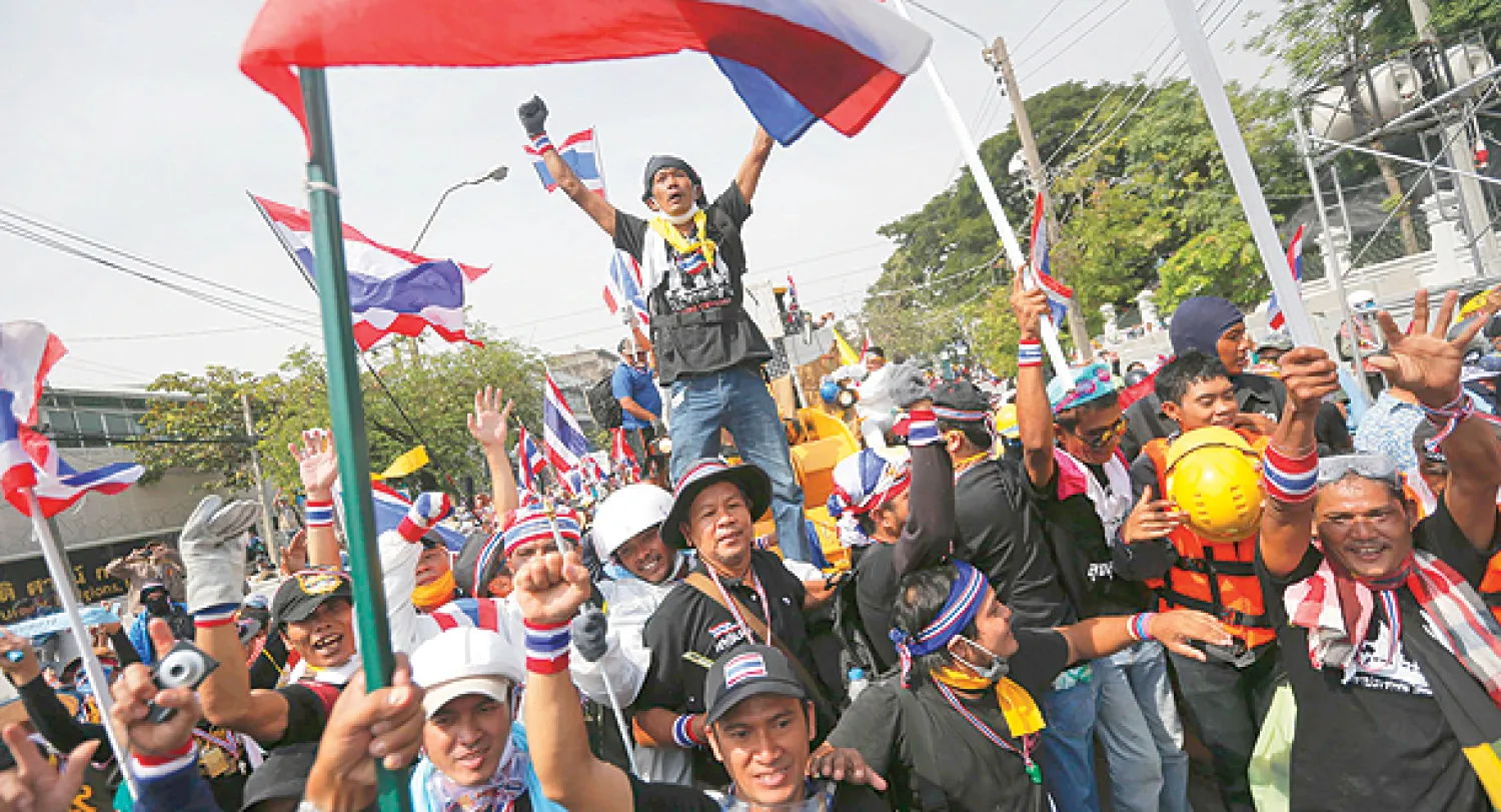 فرحة المتظاهرين المطالبين بتنحي رئيسة الوزراء التايلندية ينغلوك شيناواترا عقب اقتحامهم المجمع الذي يضم مقر الحكومة بكثافة دون أن يواجهوا مقاومة في العاصمة بانكوك أمس (رويترز)