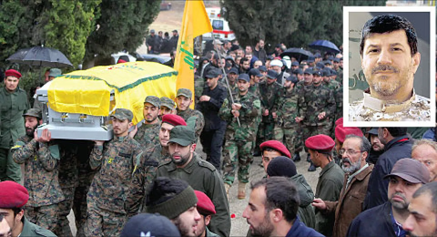 قوات من حزب الله أثناء تشييع جثمان أحد قيادييها (في اطار الصورة) الذي قتل في عملية مساء أول من أمس (إ.ب.أ)