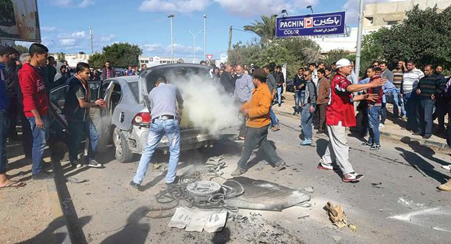 ليبيون يتجمعون حول حطام سيارة تخص أحد ضباط الاستخبارات عقب انفجار قنبلة فيها في مدينة بنغازي أمس (رويترز)