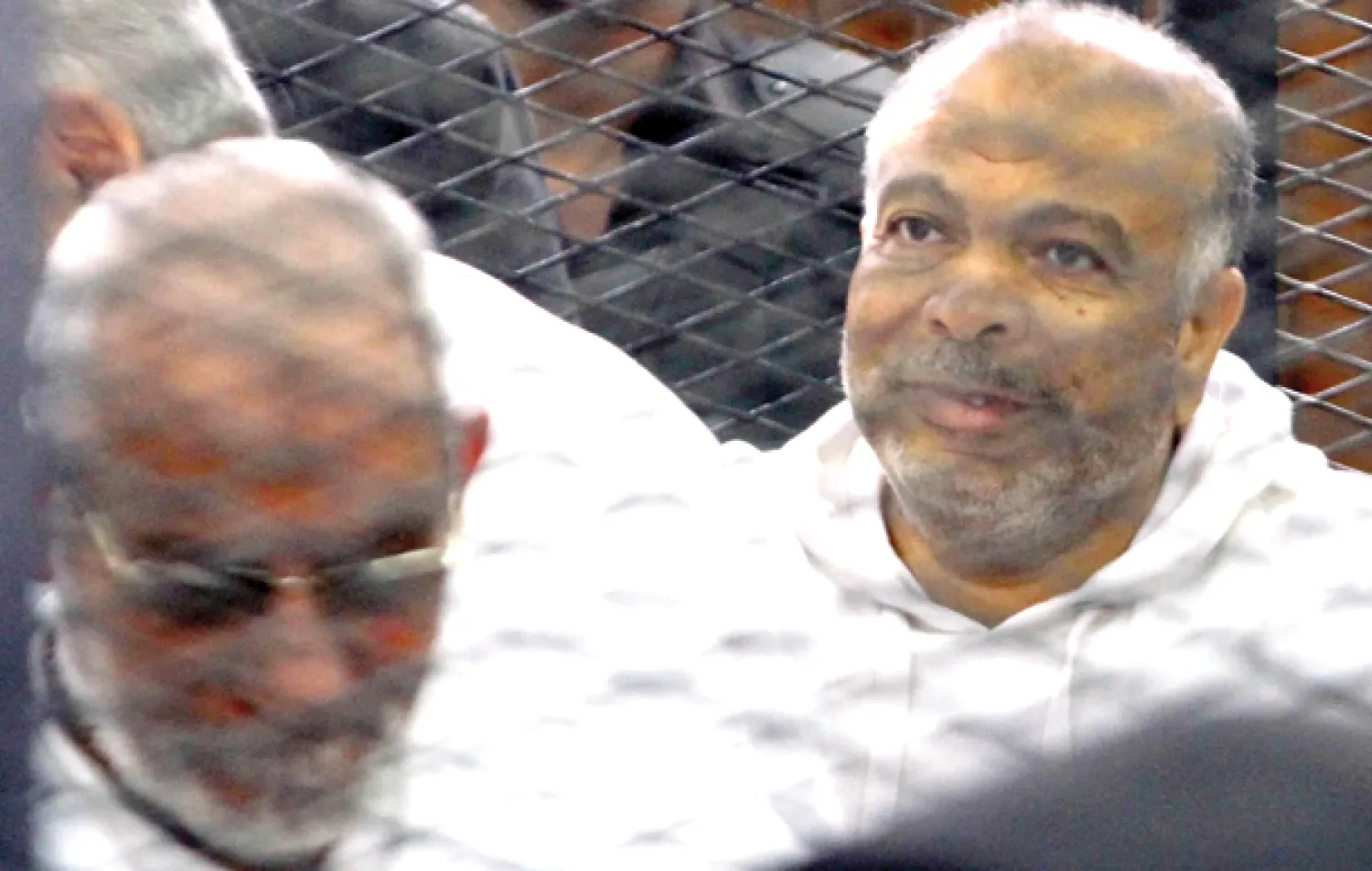 مرشد الإخوان المسلمين محمد بديع والقيادي سعد الكتاتني (يمين) خلال ظهورهما في جلسة محاكمتهما الأولى بقضية «مكتب الإرشاد» في القاهرة أمس (رويترز)