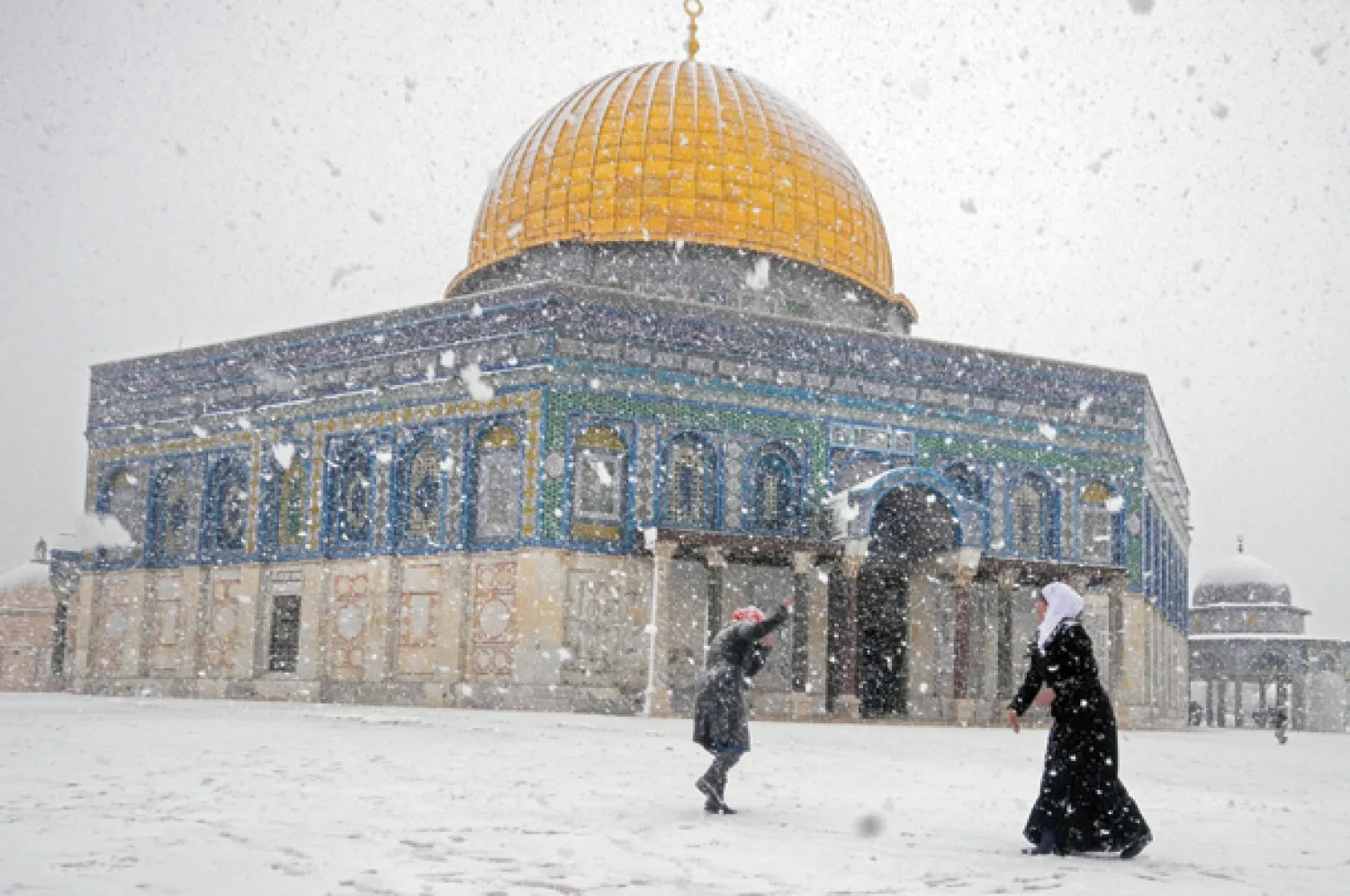 فلسطيني يحمل ابنته بعد أن داهم بيته الفيضان الناتج عن الأمطار الغزيرة في مدينة رفح أمس (رويترز)
