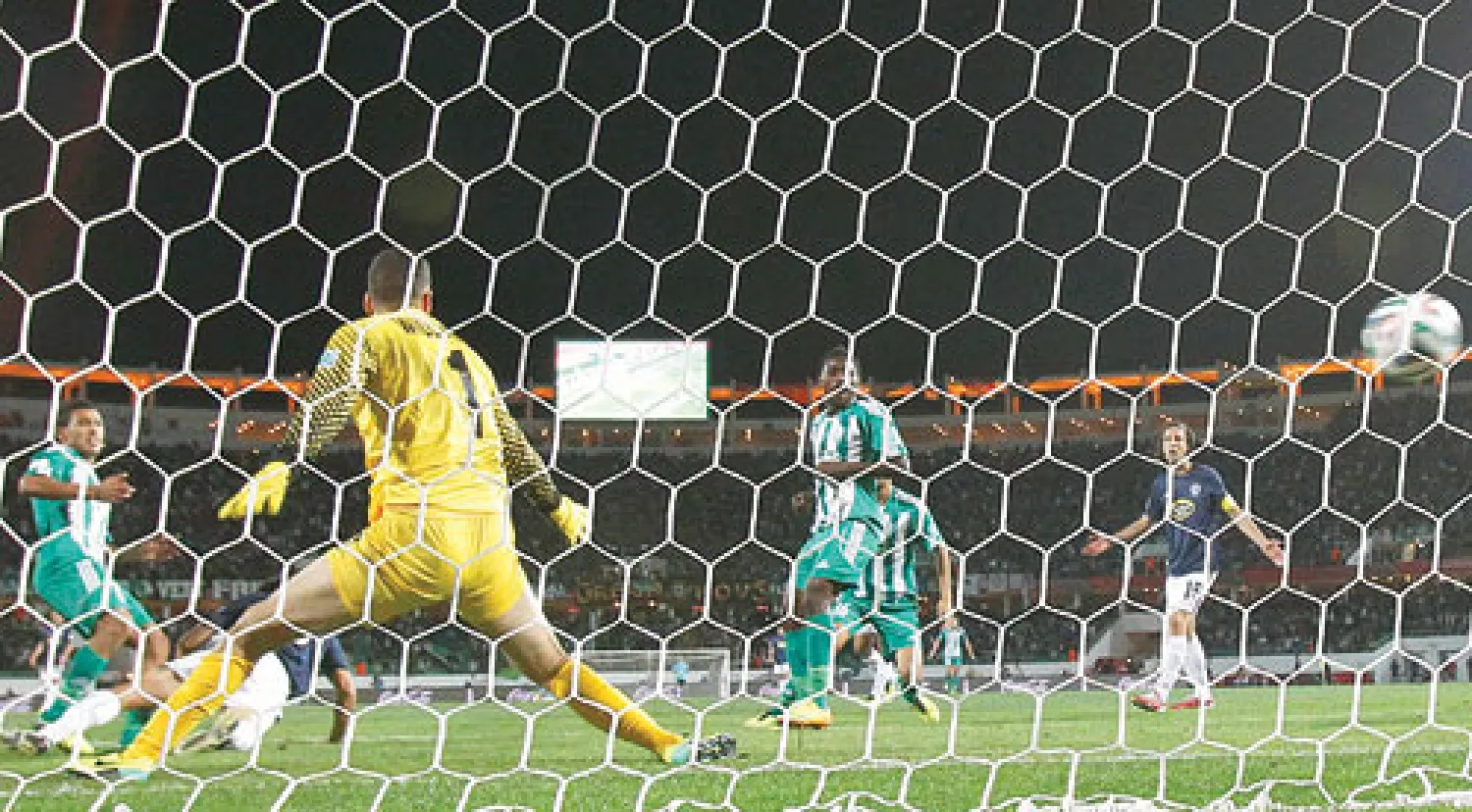 الحافيظي لاعب الرجاء (يسار) يراقب تسديدته وهي تسكن شباك فريق أوكلاند لتمنح فريقه الفوز (رويترز)