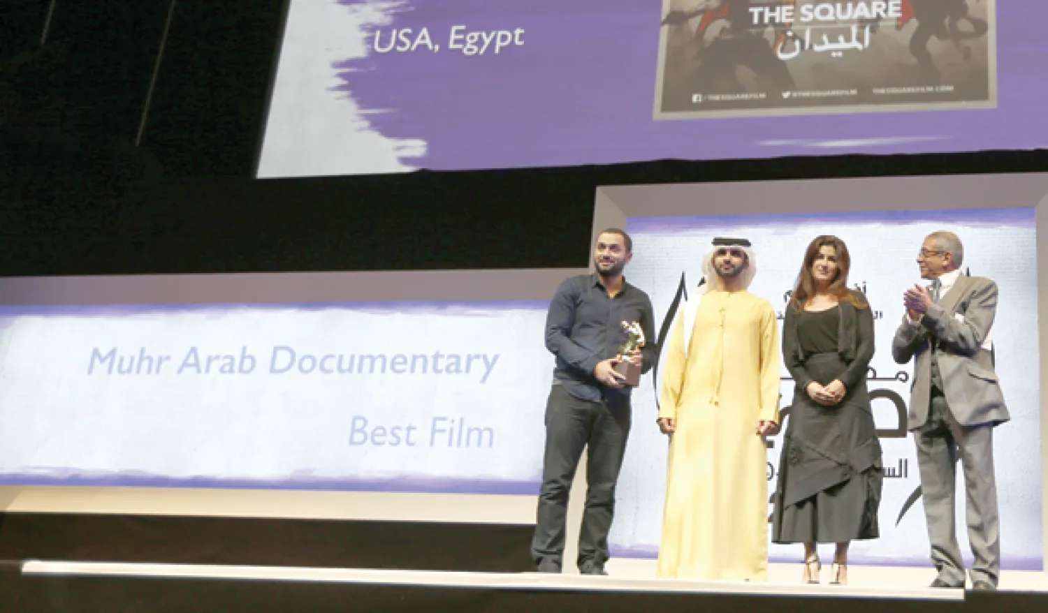 الشيخ منصور بن محمد بن راشد آل مكتوم يسلم جائزة المهر للأفلام التسجيلية لكريم عمرو عن فيلم الميدان (أ.ف.ب)