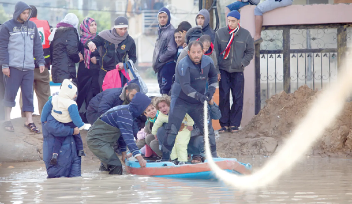 رجال الإنقاذ يساعدون السكان على إخلاء الأحياء التي غمرتها مياه الفيضانات في مدينة غزة (أ.ب)