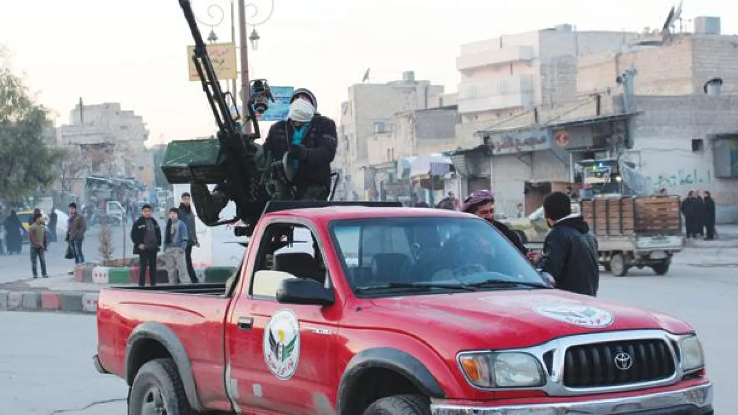 مقاتل ملثم على متن عربة في حلب القديمة (رويترز)