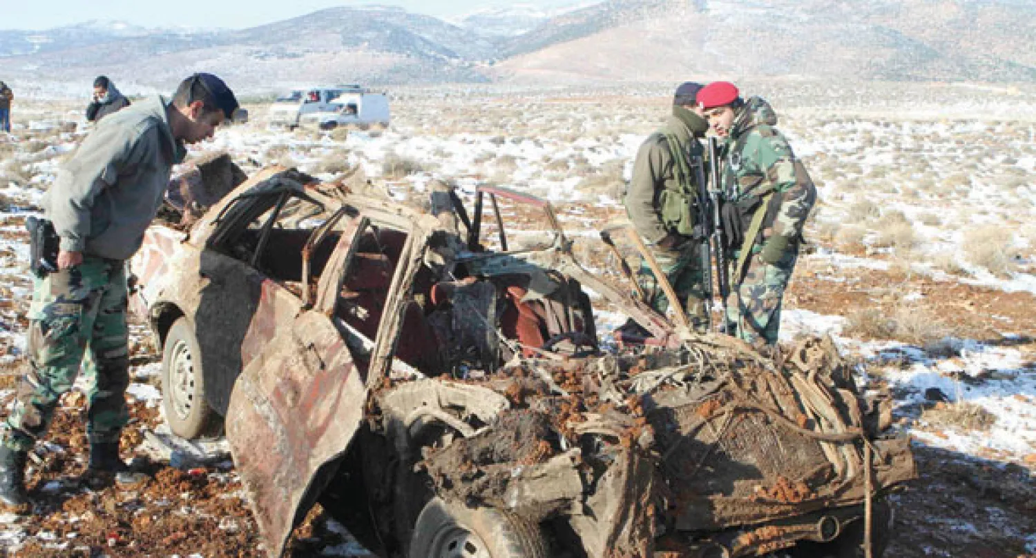 جنود لبنانيون يتفحصون حطام إحدى السيارات في موقع التفجير في البقاع اللبناني أمس (رويترز)