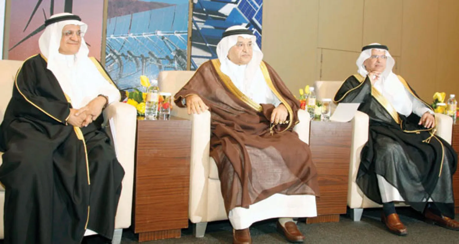 يماني يتوسط السليمان (يمين) ومحمد السويل رئيس مدينة الملك عبد العزيز للعلوم والتقنية (تصوير: خالد المصري)