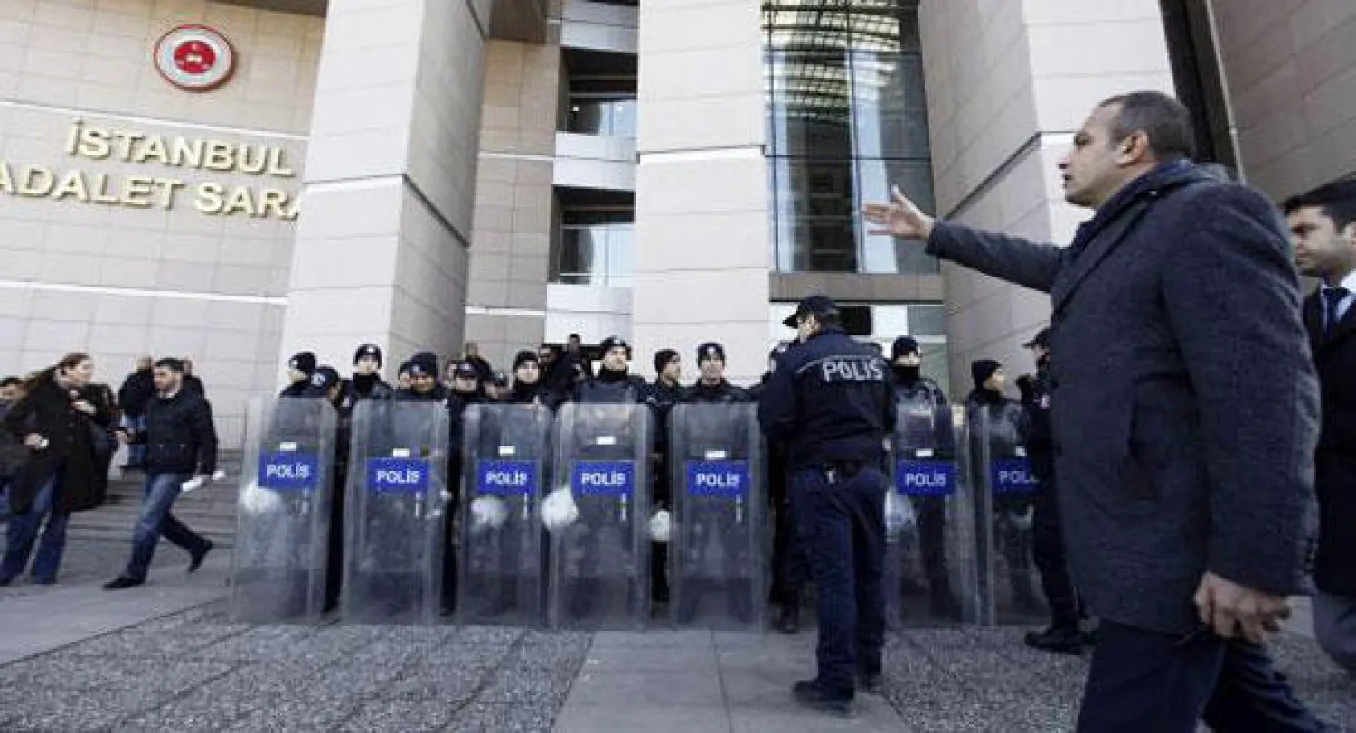 ضابط شرطة بالملابس المدنية يعطي تعليماته لشرطة منع الشغب أمام احدى المحاكم عشية اعتقال ثمانية أشخاص بشبهة الفساد (رويترز)