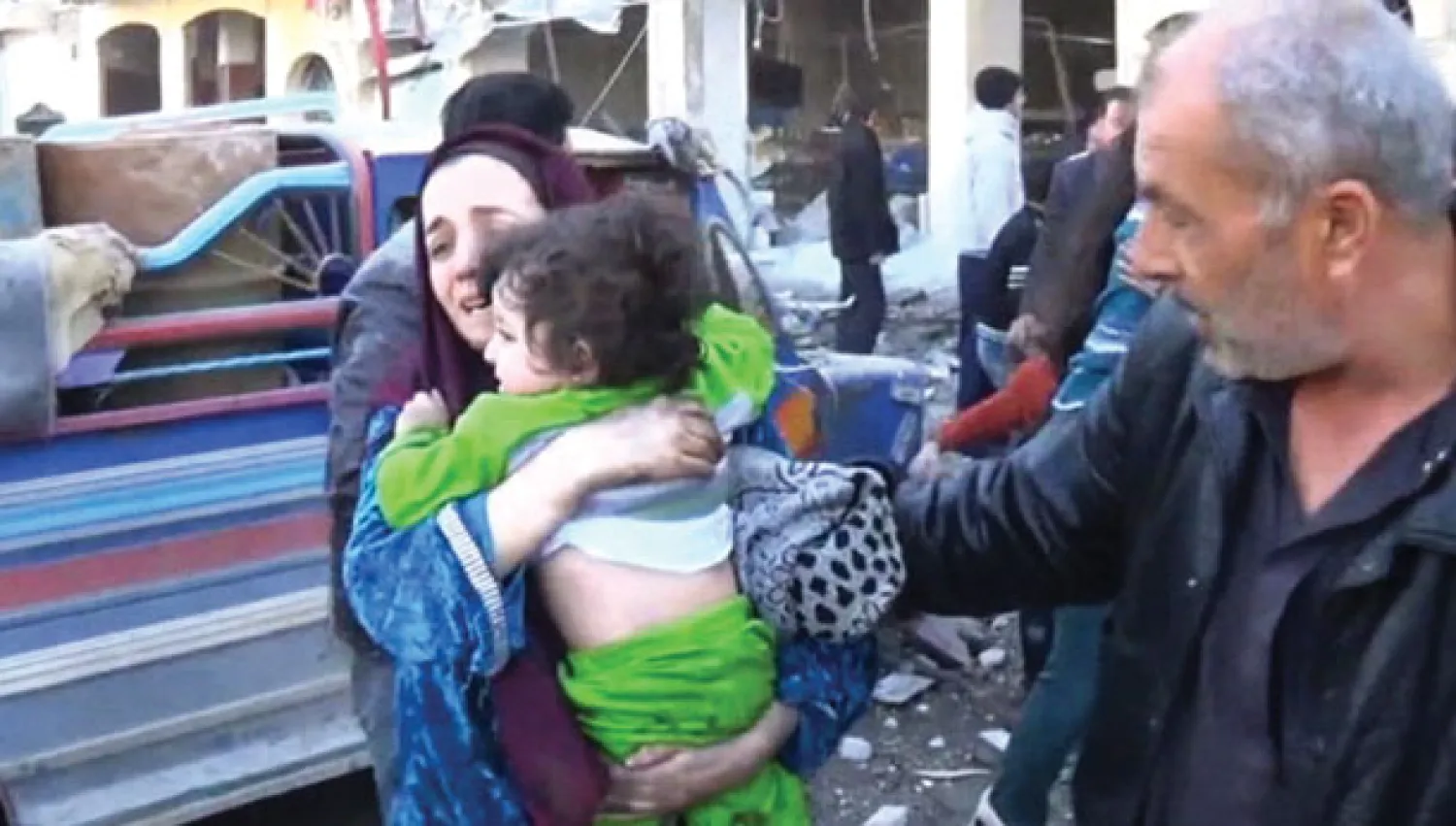 سورية تحاول الهرب بطفلها أمس بعد تعرض منزلها في أحد أحياءحلب لقصف جوي عنيف باستخدام البراميل المتفجرة (أ.ب)