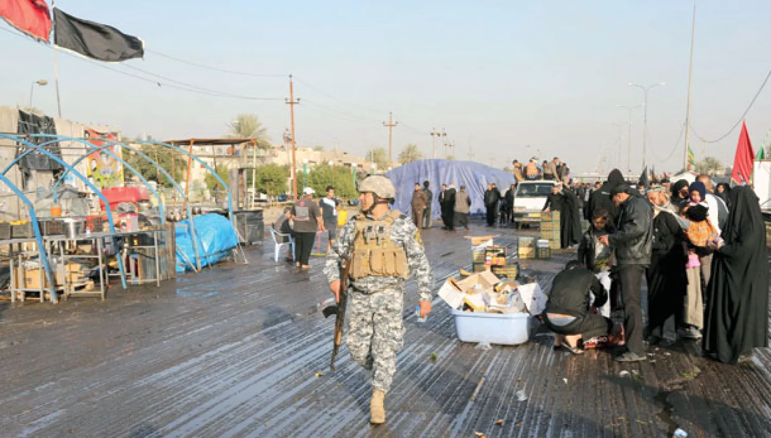 رجل أمن يقوم بدورية في أحد الشوارع بالدورة حيث شهدت عملية انتحارية أمس (أ.ب)