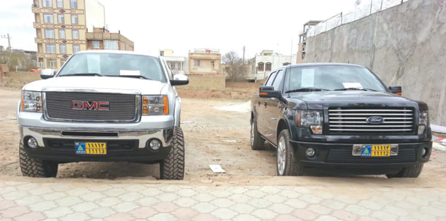 شاحنتان من طراز فورد (إلى اليمين) وأخرى من طراز جي إم سي في توكيل سيارات بالمنطقة الحرة في مدينة أراس شمال غربي إيران (رويترز)