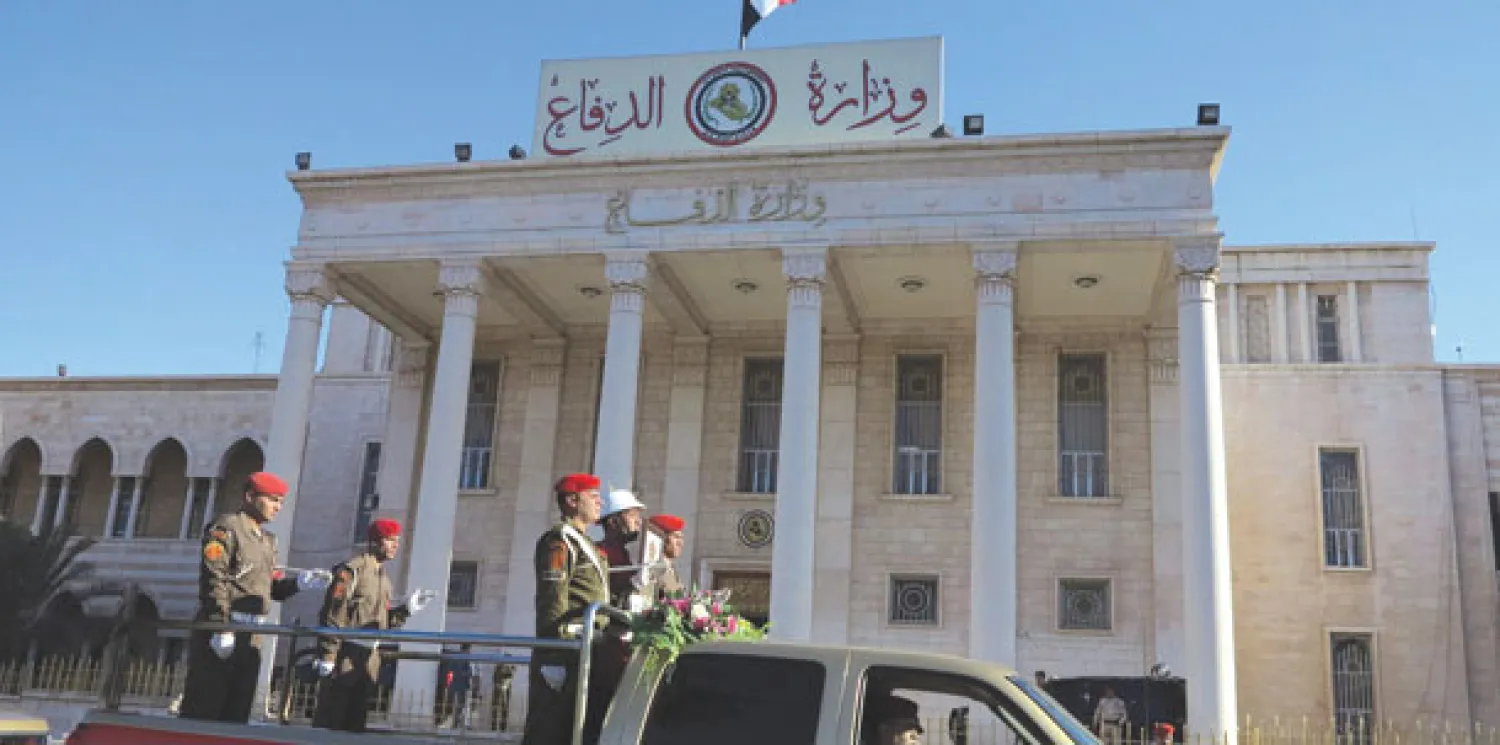 شاحنة «بيك آب» عسكرية تحمل نعش قائد الفرقة السابعة العميد الركن محمد الكروي تمر أمام مبنى وزارة الدفاع في بغداد خلال مراسم تشييع جنازته أمس (أ.ف.ب)