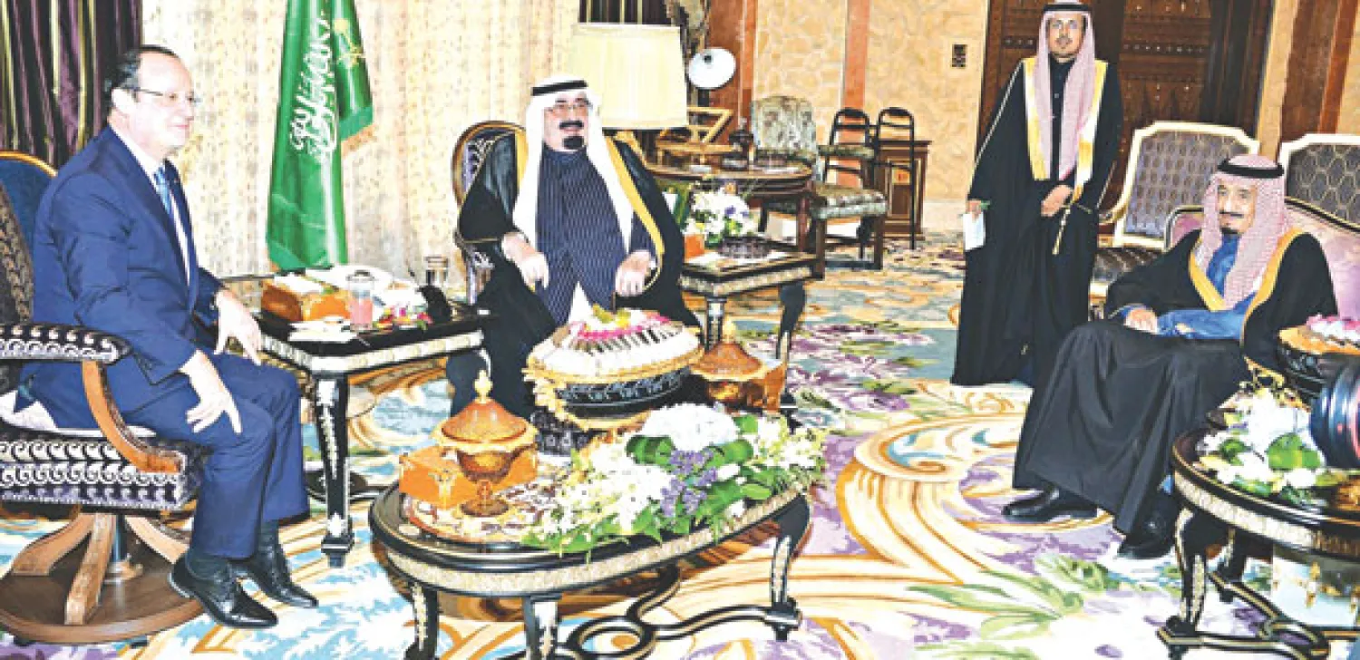 خادم الحرمين الشريفين لدى استقباله الرئيس هولاند في روضة خريم بالرياض أمس (واس)