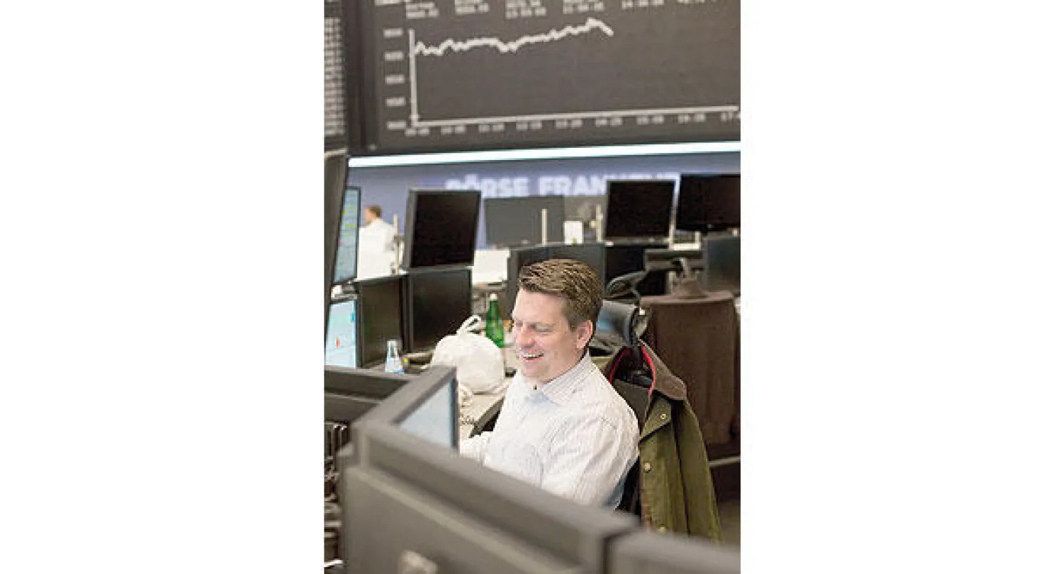 متداول في بورصة فرانكفورت تظهر عليه علامات السعادة بعد ارتفاع المؤشر لمستويات تاريخية (إ.ب.أ)