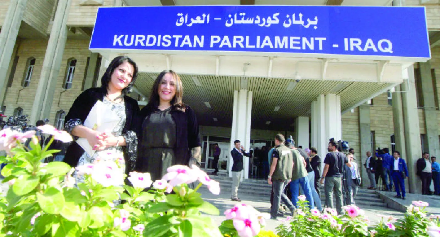نائبتان في البرلمان الكردستاني المنتخب تقفان أمام مبنى البرلمان في أربيل بعد أداء اليمين القانونية في 6 نوفمبر الماضي (أ.ف.ب)