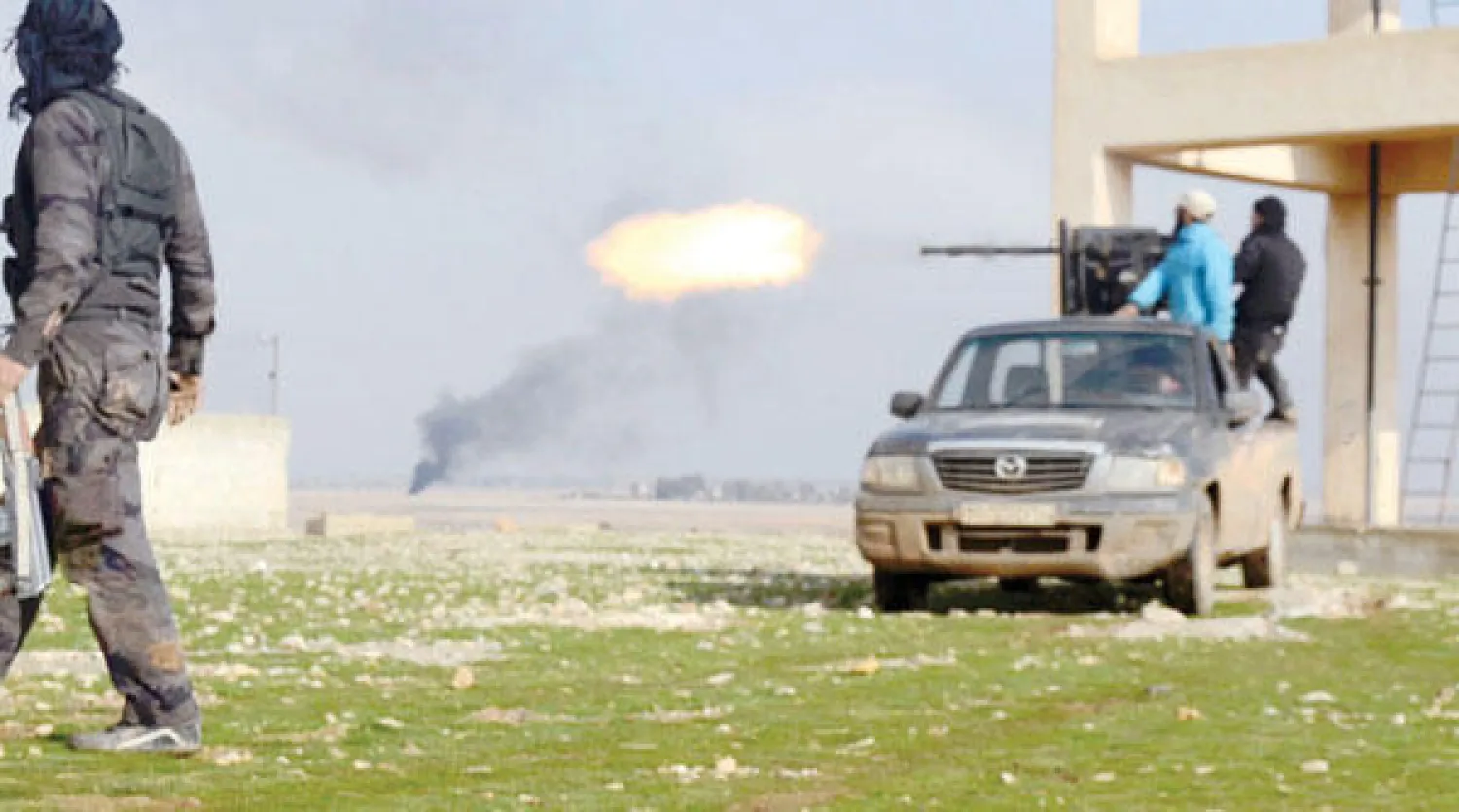 مقاتلون من الجيش السوري الحر يطلقون النار أمس باتجاه قوات نظامية سورية في محافظة حماه، أمس (رويترز)