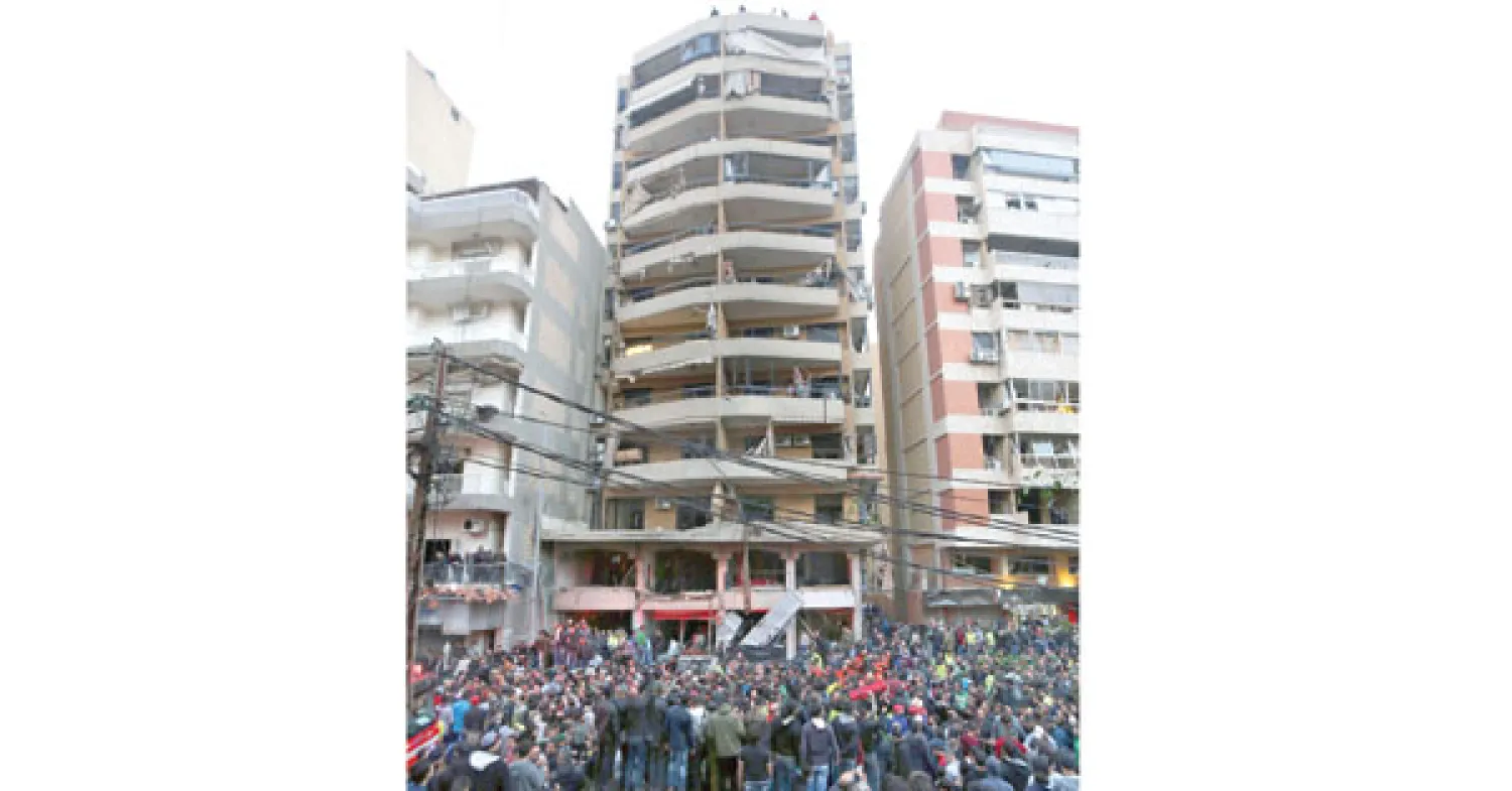 تجمع لسكان المنطقة لمعاينة موقع التفجير في ضاحية بيروت الجنوبية (أ.ب)